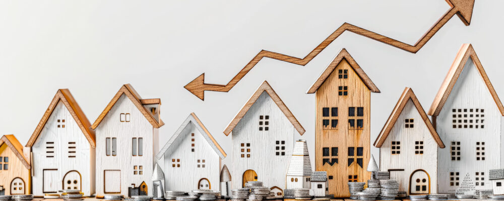 A row of wooden houses with a downward arrow pointing to the right and arrow pointing down to the left. Student loan forgiveness and housing market stimulus.